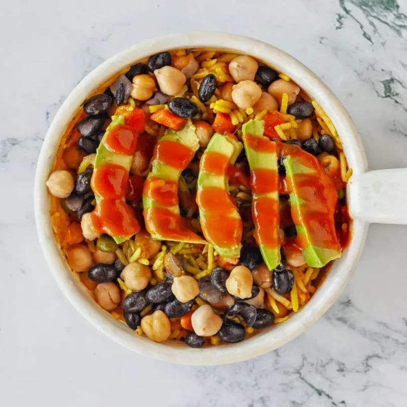 Appu's Turmeric Cafe's Indian bowl with rice, chickpeas, black beans, avocado, and red sauce.